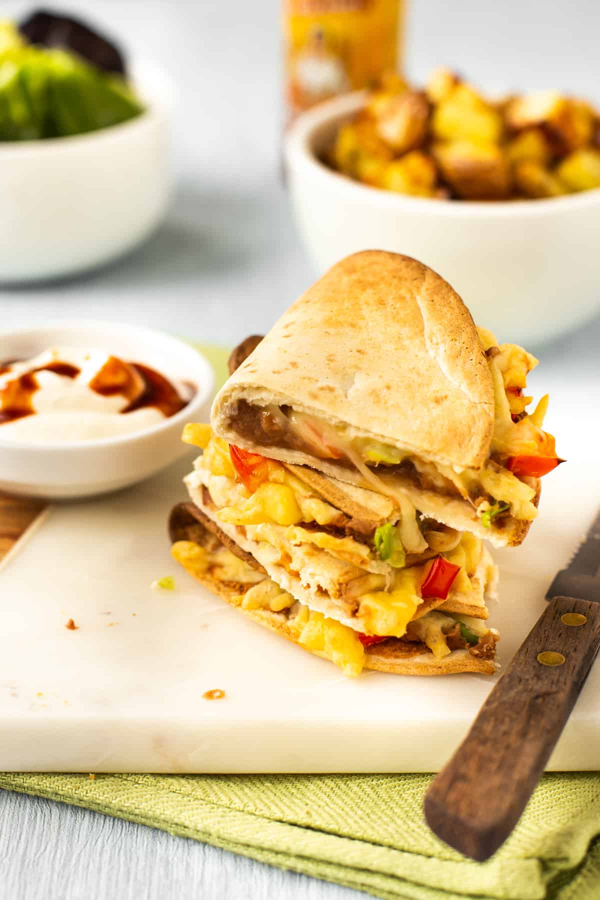 A stack of crispy refried bean quesadillas on a board.