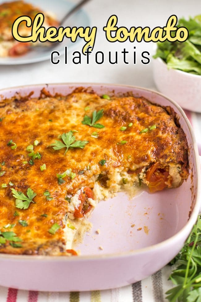 Cheesy cherry tomato clafoutis in a pink baking dish with a scoop removed