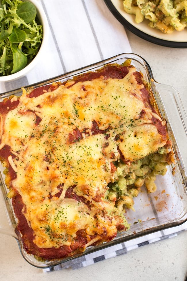 Cheesy pasta bake in a pyrex dish with a portion removed, shot from above