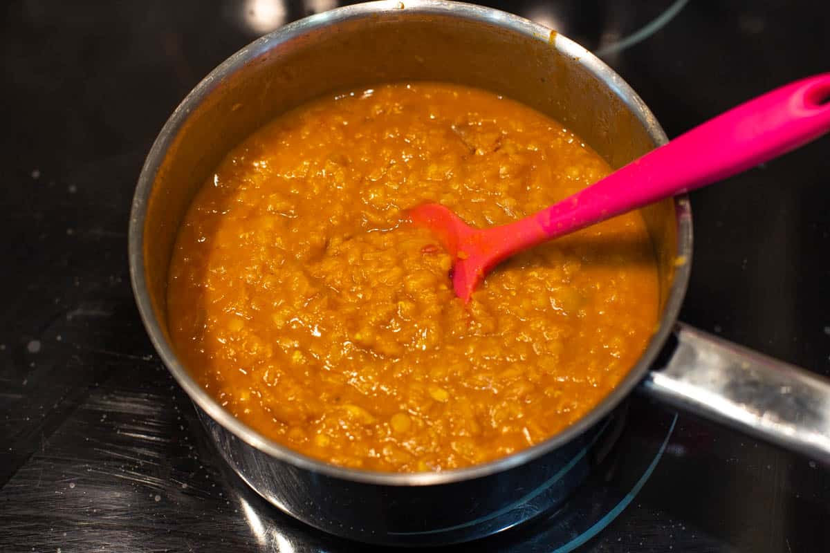 Soft cooked lentils in a saucepan.