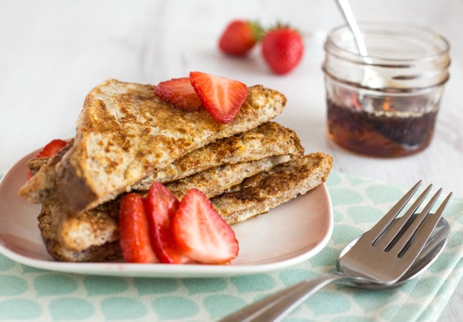 A stack of healthier French toast with fresh strawberries.