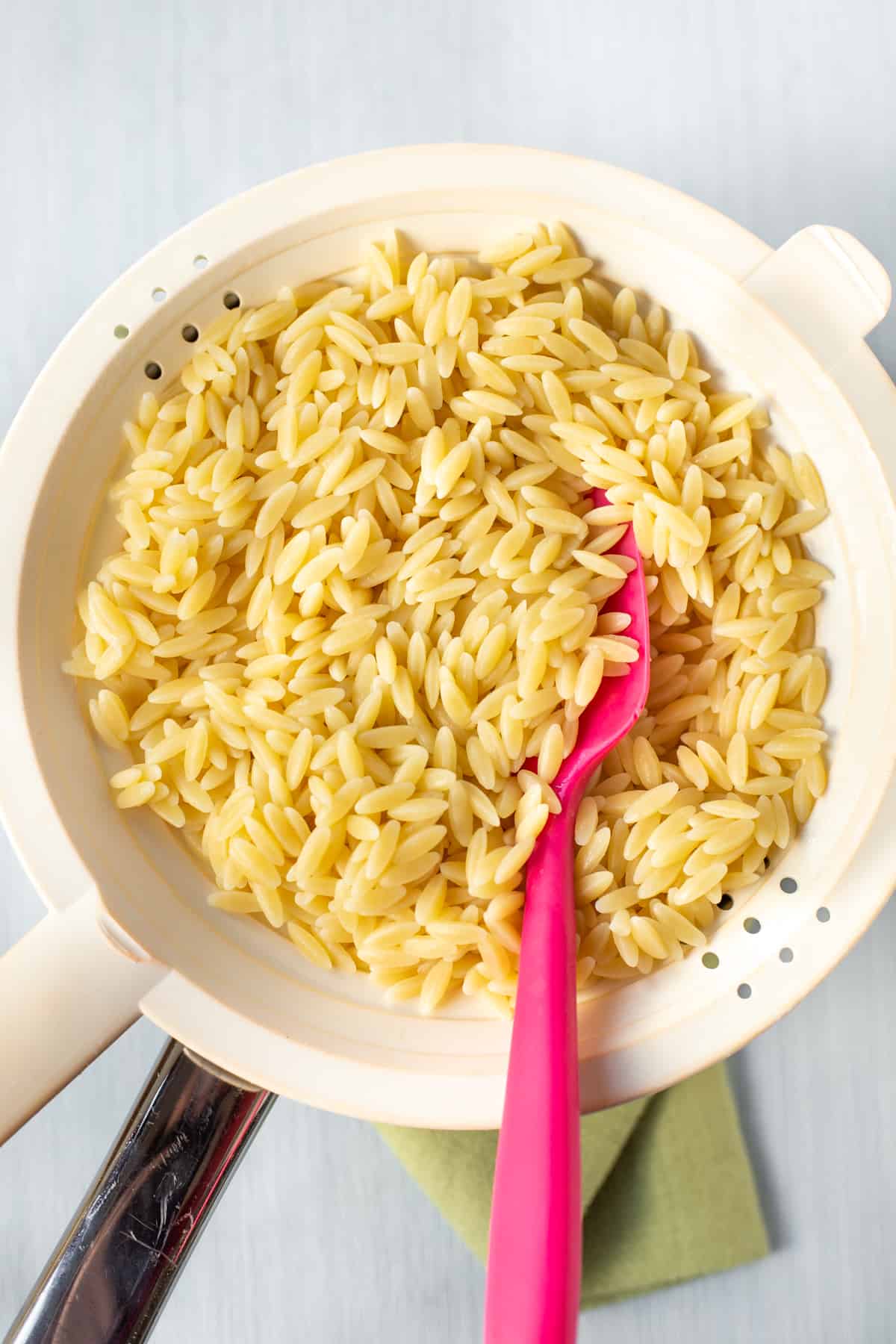 Cooked orzo in a colander.