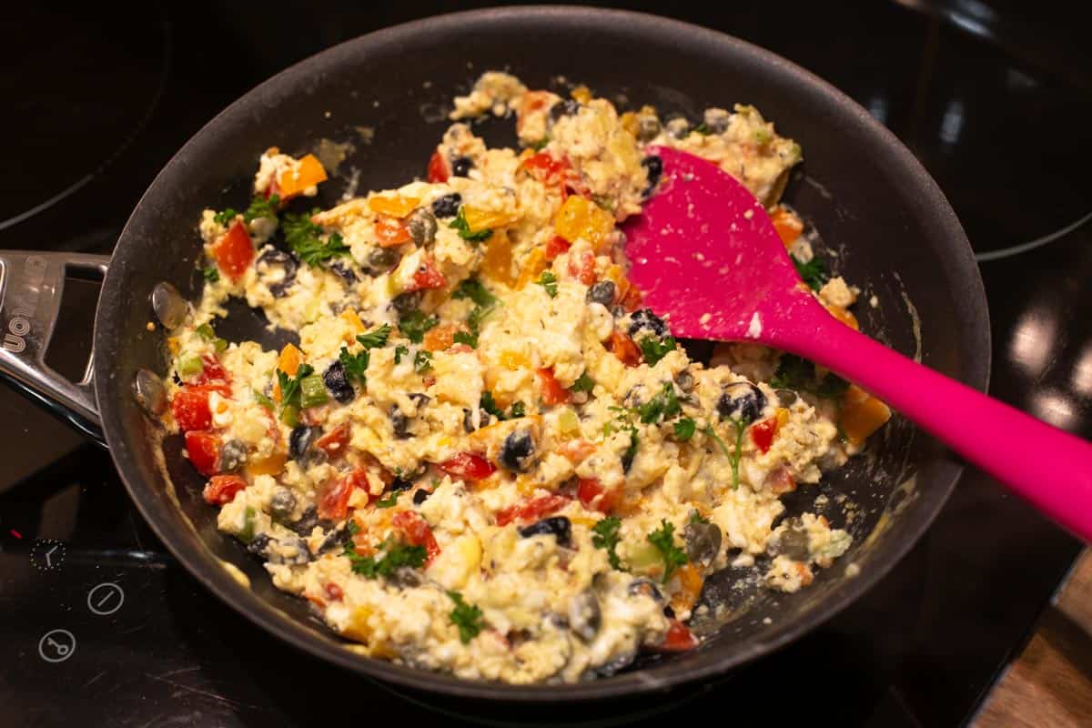 Mediterranean scrambled eggs cooking in a frying pan.
