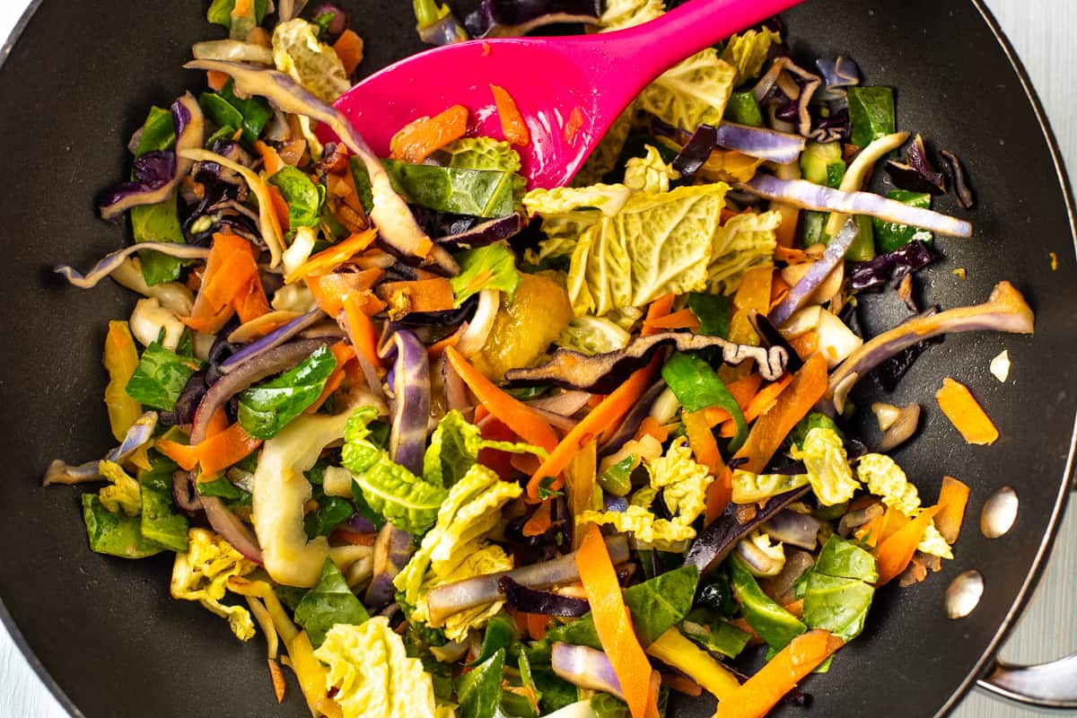 Mixed stir fry vegetables cooking in a wok.