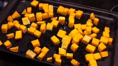Diced roasted butternut squash on a baking tray.