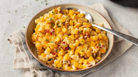 A bowl of slow cooker corn casserole with a spoon.